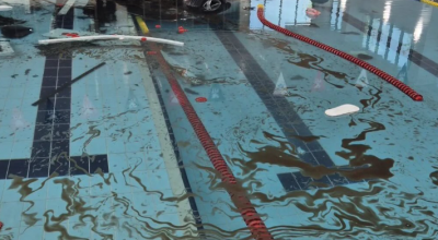 Telecamera di sorveglianza riprende auto di una pensionata che vola in piscina dopo aver sfondato una parete di vetro
